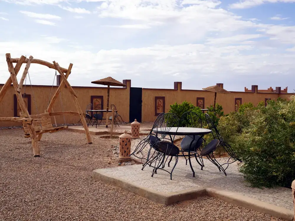Garden with a wooden swing and seating at the riad