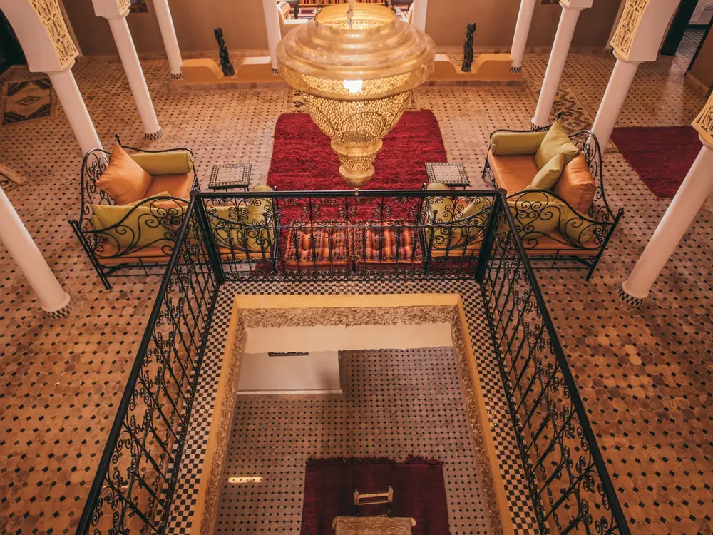 View from above of the riad's courtyard lounge, carved arches and hanging lantern