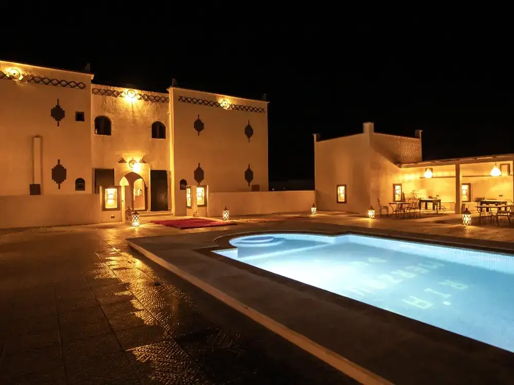 The riad pool courtyard lit up at night
