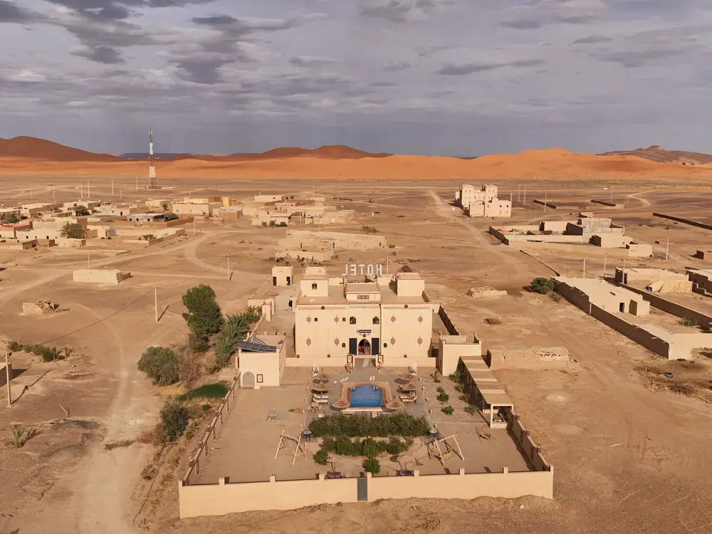 Aerial view of the riad in Ksar Tabomiat with the Erg Chebbi dunes behind