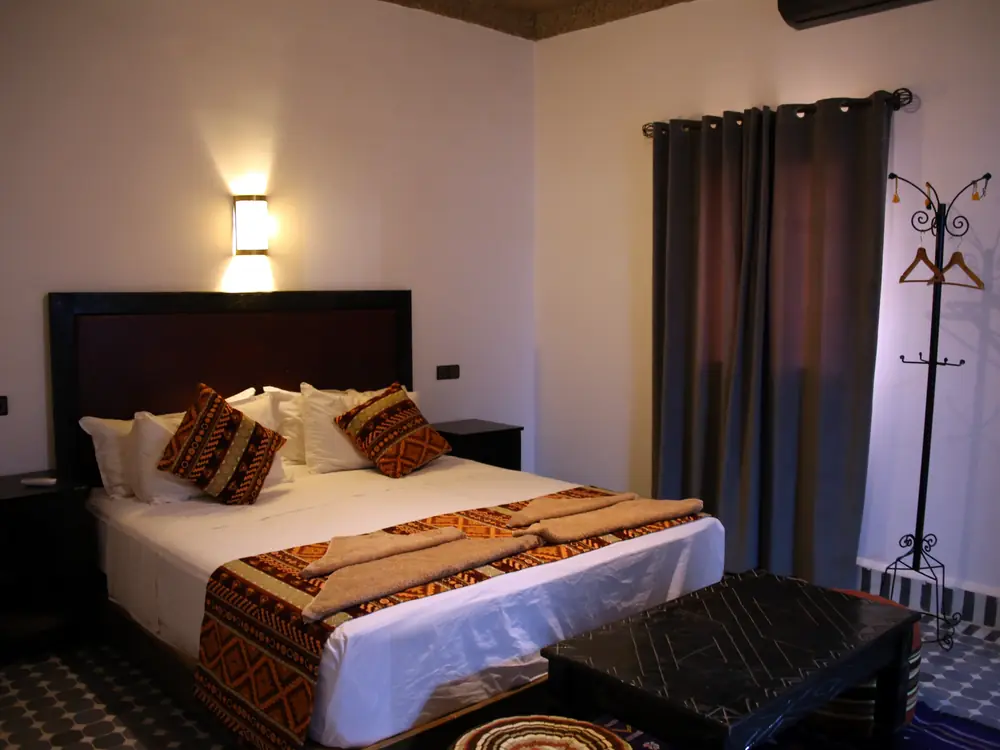 Double bed with Berber textiles and a low wooden table