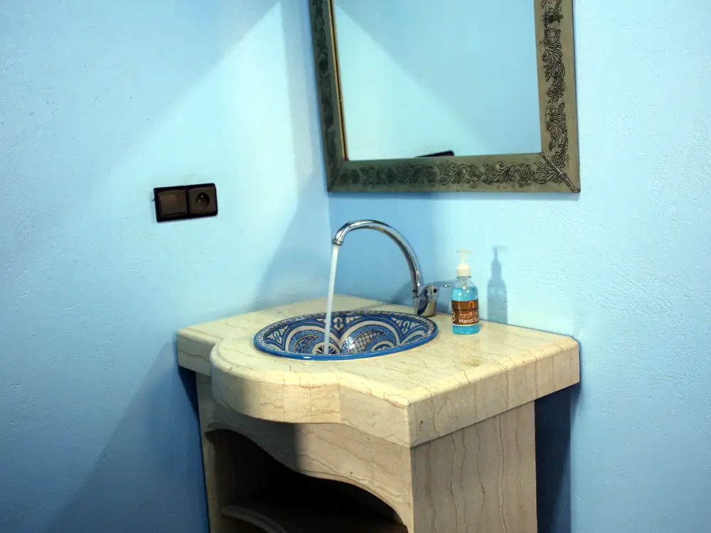 Blue tadelakt bathroom with hand-painted ceramic sink