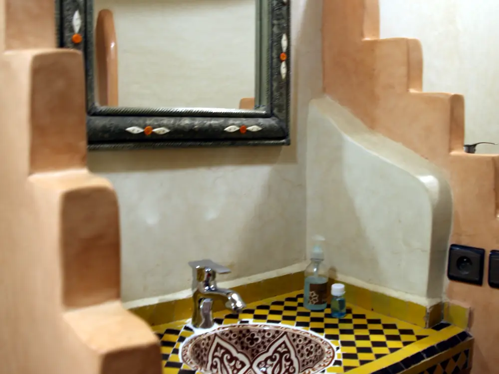 Bathroom with yellow zellige tiles and engraved sink